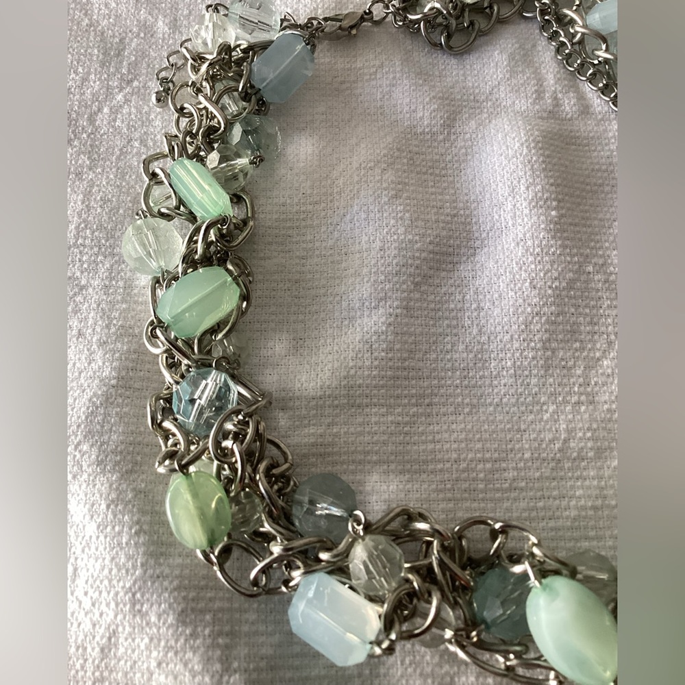 Pale green & blue acrylic stones interwoven in silver chain link strands.